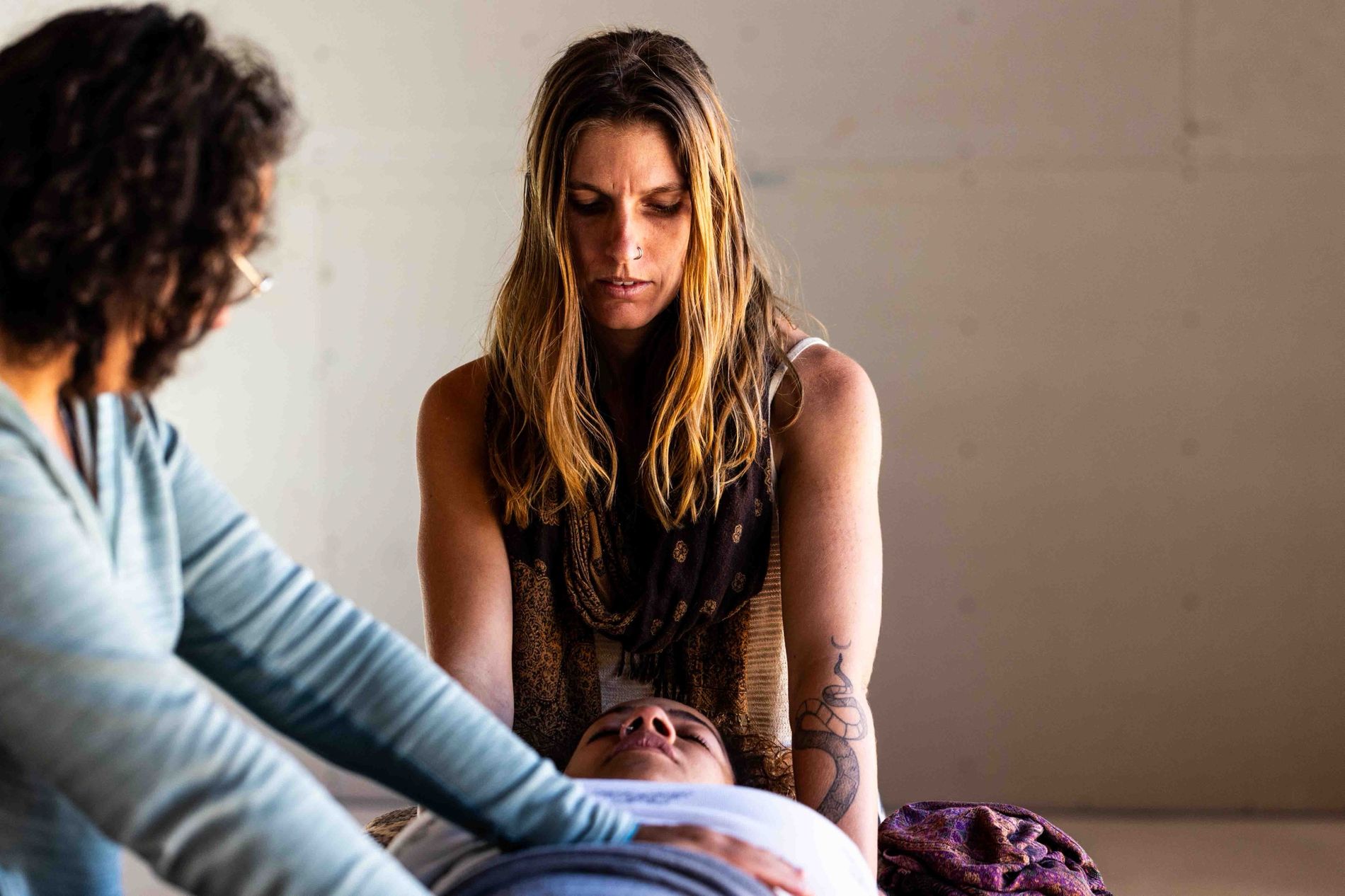 Madison facilitating bodywork with a participant in the foreground