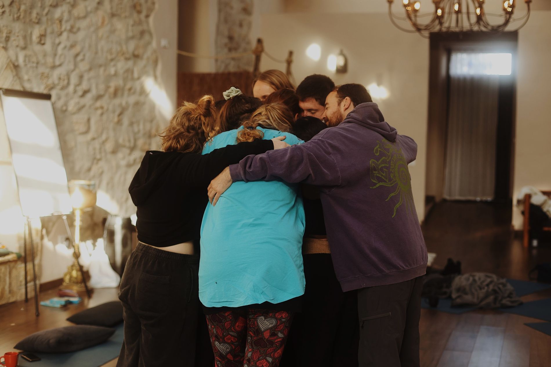 A group standing in a close circle in a stone room