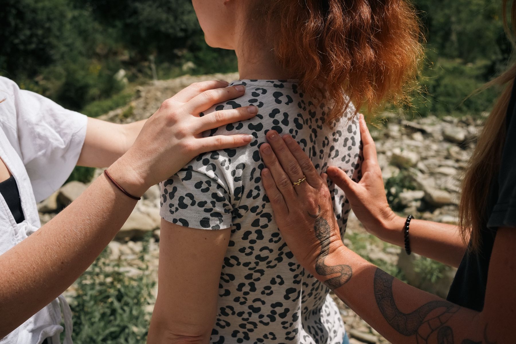 Hands resting on a person's back and shoulder