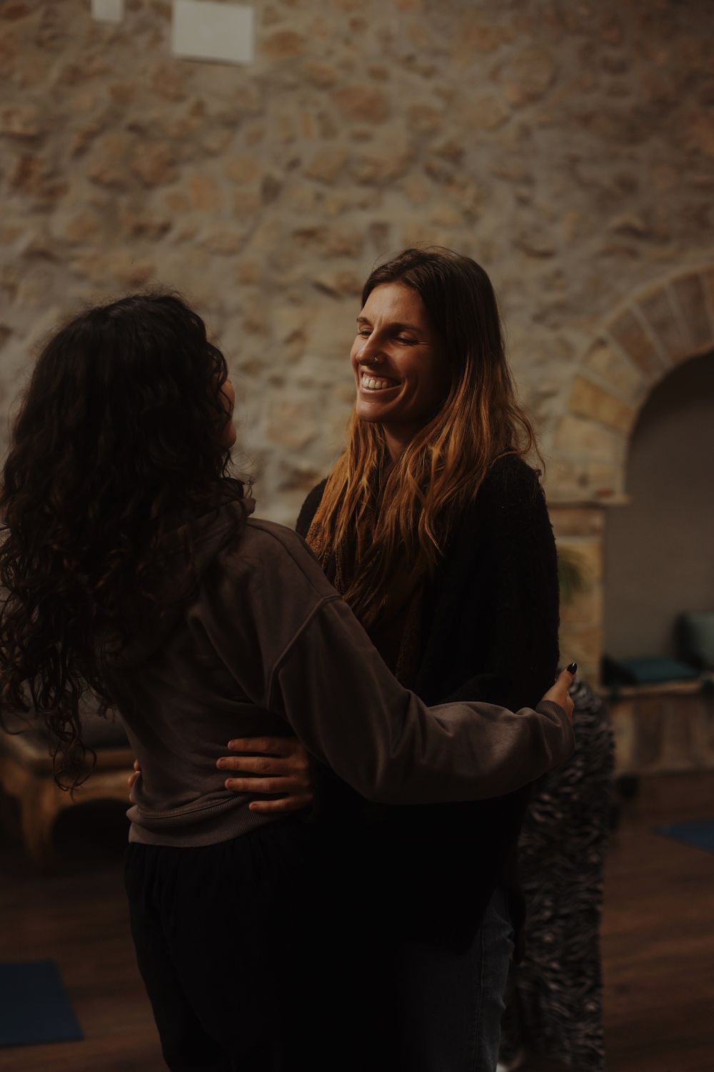Madison laughing with a participant in a stone room
