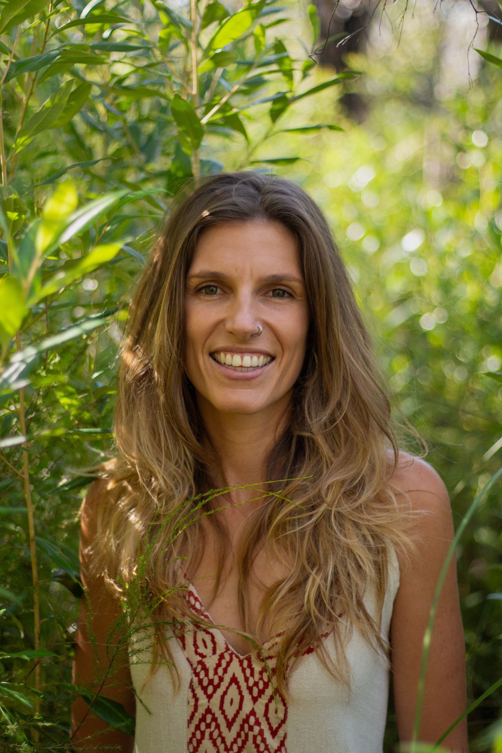 Madison Louise smiling among green leaves