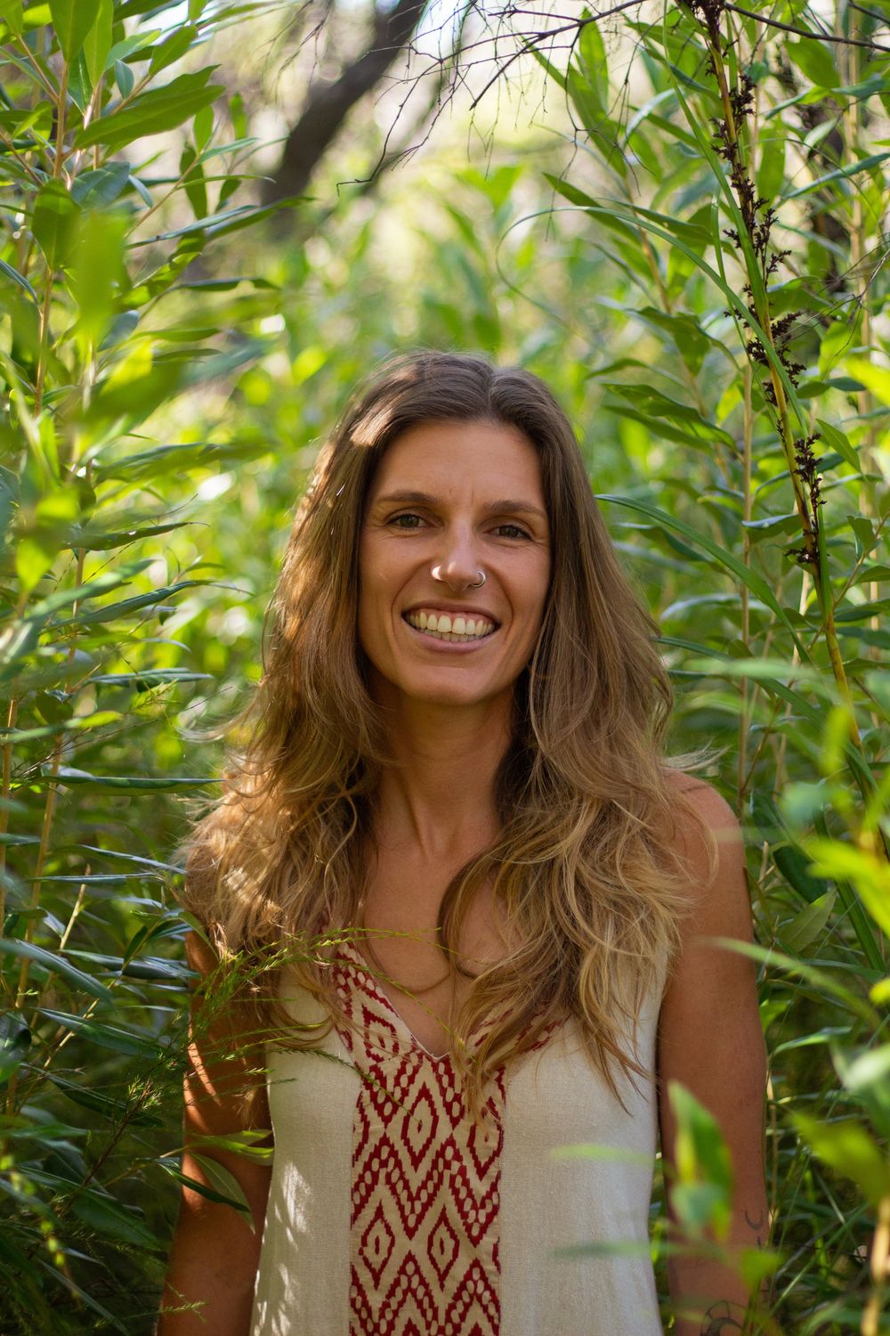 Madison smiling among green leaves